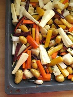 a tray filled with assorted veggies on top of a wooden table