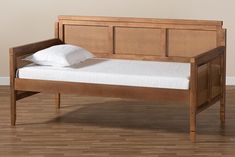 a wooden bed frame with white pillows on it