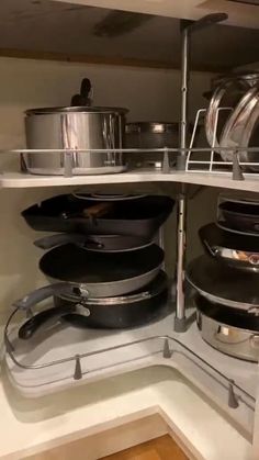 pots and pans are sitting on shelves in the kitchen