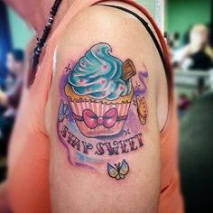 a woman with a cupcake and butterfly tattoo on her arm that says stay sweet