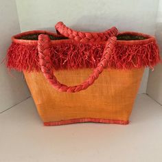 "Savannah",Beautiful Large Orange Straw Tote Bag with Small Pocket,Rectangle Bottom,made of Natural Straw and "Uniquely Hand Crafted." From My Personal Collection."This Straw Tote Bag has Braided Rope Handles and 4" Long Fringe around the top and has a outside Woven Fabric with the Inside and Bottom in Natural Straw.A Really Fun Bag that is Great for Lots of Occasions."From a Pet Free and Smoke Free Enviroment." Red Straw Shopping Bags, Summer Orange Bucket Straw Bag, Orange Bucket Straw Bag For Summer, Orange Tote Straw Bag For Summer, Red Straw Tote Bag, Orange Bucket Straw Bag For Vacation, Handmade Orange Beach Bag For Summer, Casual Orange Crochet Bucket Bag, Orange Handheld Beach Bag