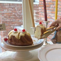 a person cutting into a bundt cake on a plate