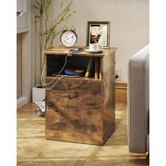 a wooden cabinet with a clock on top and other items in it next to a couch