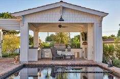 an outdoor kitchen and dining area with a pool