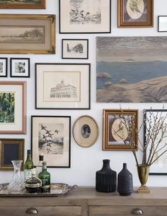 there are many framed pictures on the wall with vases and bottles next to them