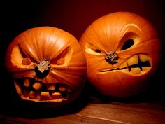 two pumpkins with faces carved into them