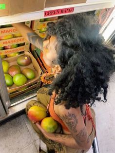 a woman standing in front of a refrigerator filled with fruit