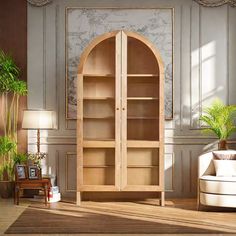 a living room filled with furniture and a wooden book shelf next to a chair on top of a hard wood floor