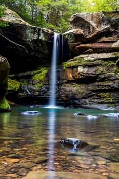 a small waterfall in the middle of a forest