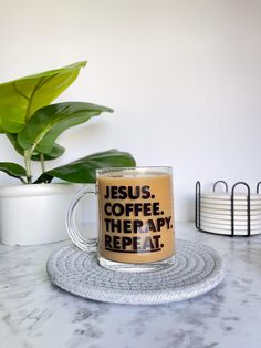 a coffee mug with the words jesus, coffee, and therapy on it sitting on a coaster