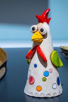 a ceramic chicken figurine sitting on top of a table