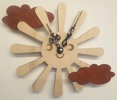 a clock made out of wooden sticks with scissors on the face and two hearts in the middle