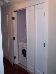 a washer and dryer are in the corner of a room with white doors