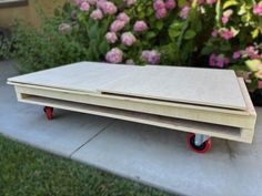 two pieces of plywood sitting on top of each other in front of some flowers