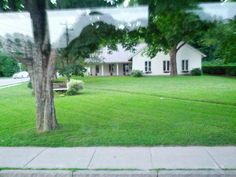 a house is seen through the window of a car parked on the side of the road