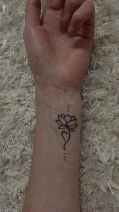 a woman's wrist with a small tattoo on it