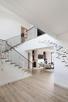 a living room filled with lots of furniture and birds flying over the top of it