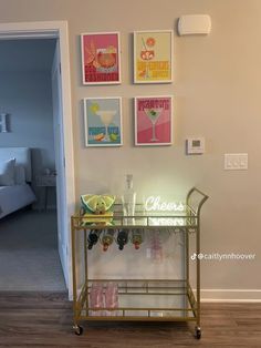 a bar cart with wine glasses and lemons on it in front of a bedroom door