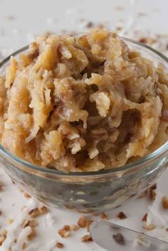 coconut pecan frosting in a glass bowl on top of a white tablecloth