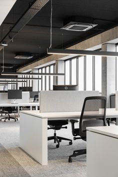 an empty office cubicle with chairs and desks