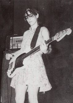 a young woman is playing the bass guitar