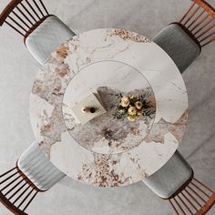 an overhead view of a marble dining table and chairs with flowers on the center piece