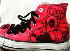 a pair of red and black shoes with deadpool designs on them, sitting on a white surface