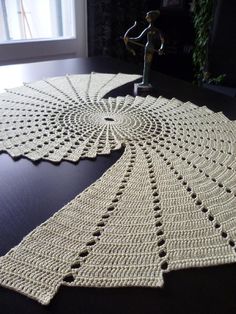 a crocheted doily sitting on top of a table next to a window