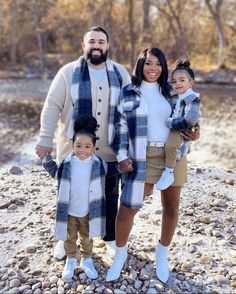 a man, woman and two children standing on rocks