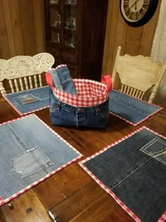 several pieces of denim sitting on top of a wooden table in front of a clock