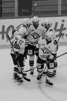 a group of young men standing next to each other on top of an ice rink