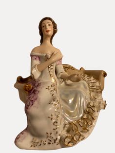 a ceramic figurine of a woman in a dress