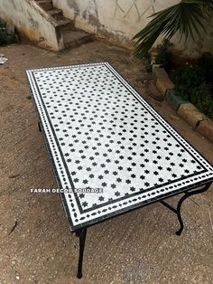 a white and black tiled table sitting on the ground