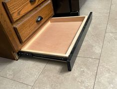 a drawer is open on the floor in front of a counter with drawers and cabinets