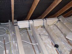 the insulation is being installed on the ceiling in this attic room, with exposed pipes and wires