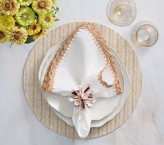 a white plate topped with a piece of cake on top of a table next to flowers