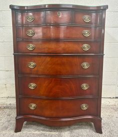 an antique chest of drawers with brass handles