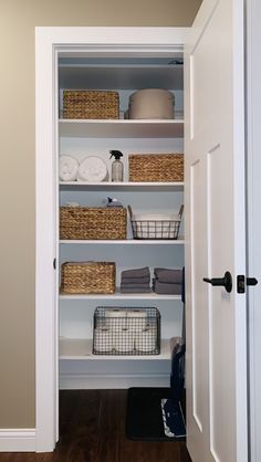 an open closet with baskets and towels