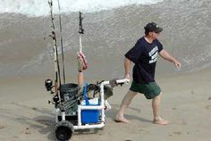 a man is walking on the beach with his fishing rod and reels in hand