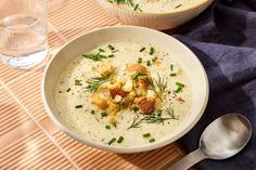 two bowls filled with soup and garnished with green onions on a place mat