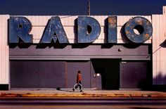 a man is walking in front of an old radio building with the word radio on it