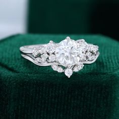 a diamond ring sitting on top of a green velvet box