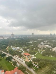 an aerial view of a city with lots of trees and buildings on the other side