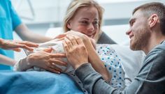 a man in a hospital bed is being assisted by two nurses and the woman has her arm wrapped around him