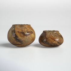 two brown vases sitting next to each other on a white surface