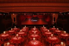 a large room with tables and chairs covered in red cloths