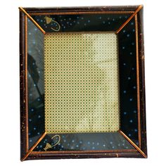 an old photo frame is decorated with blue dots and gold trimmings on the edges