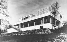 a black and white photo of a house on a hill