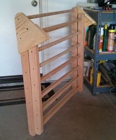 an unfinished wooden bed frame sitting in a garage next to a shelf filled with tools