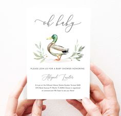 someone holding up a baby shower card with a duck in the water and greenery on it